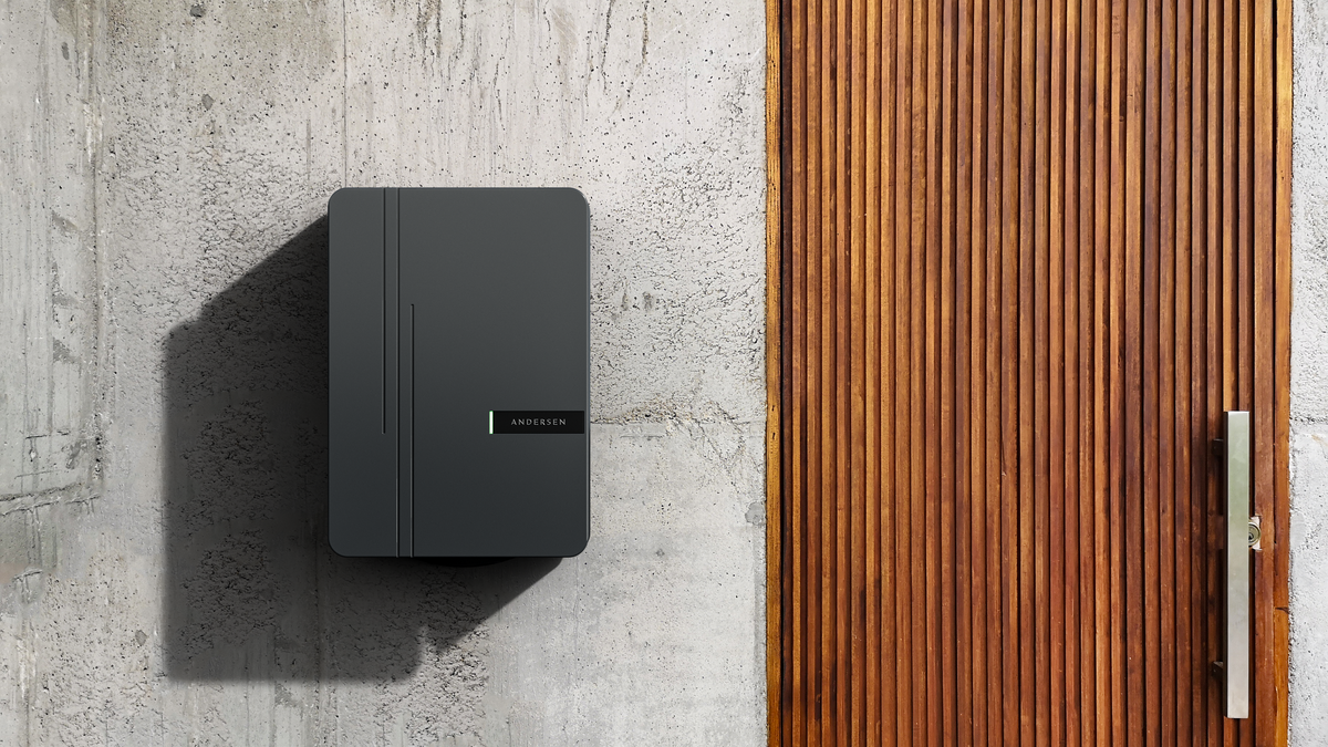 Andersen A3 EV charger in dark grey installed on concrete wall beside wood paneling - buy premium home charging point