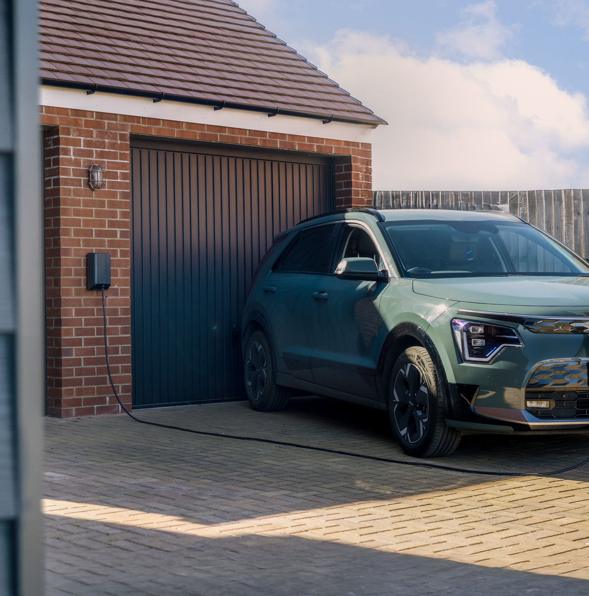 Kia EV charging via Andersen A3 quartz EV charger on brick garage wall - buy premium home charging point
