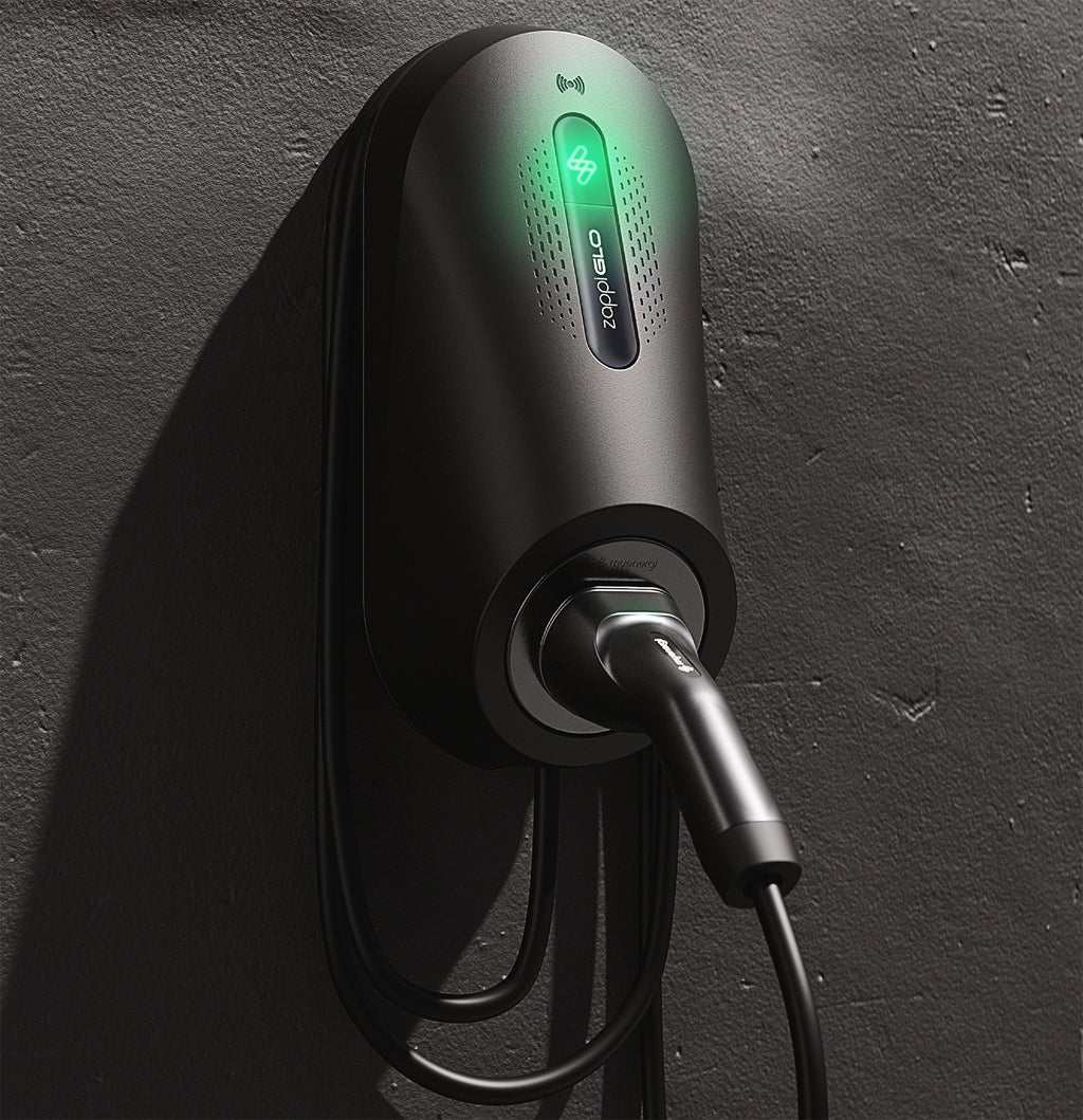 Myenergi Zappi GLO tethered home EV charger in black on rough grey wall with glowing green zappi logo, RFID icon and full Type 2 cable hanging in loop