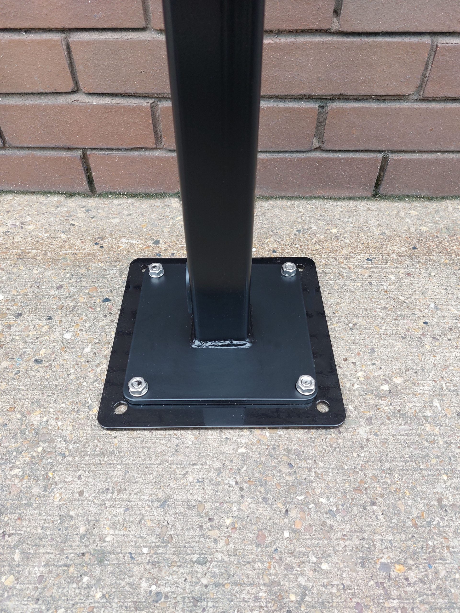 EV charger pedestal black metal post mounted onto evblock mini adaptor plate installed on concrete floor with mounting base plate