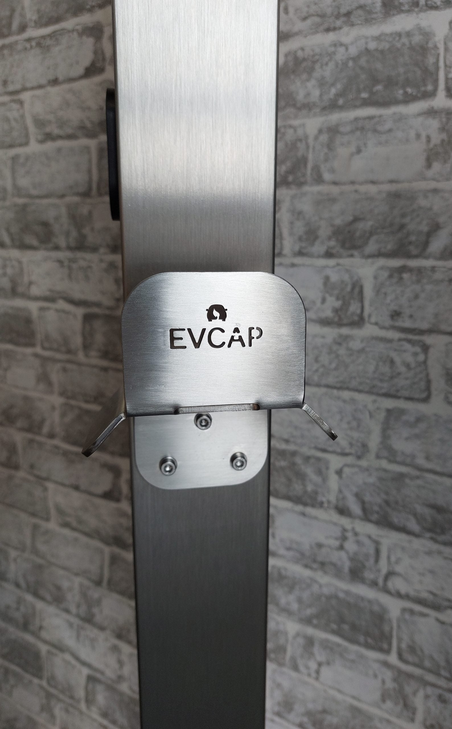 EV charger cable management bracket stainless steel front view installed against brick wall