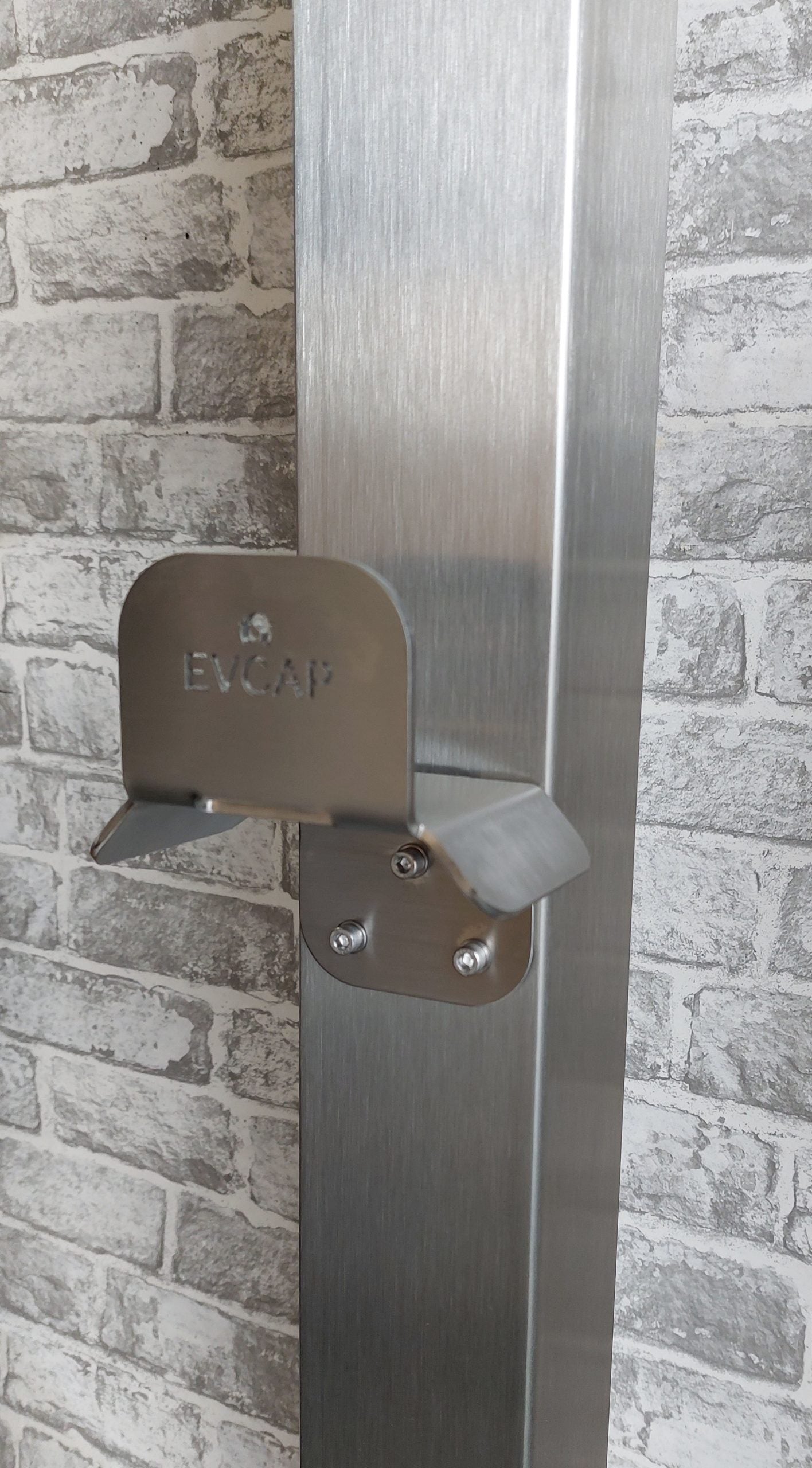 EV charger cable management bracket stainless steel side view installed against brick wall