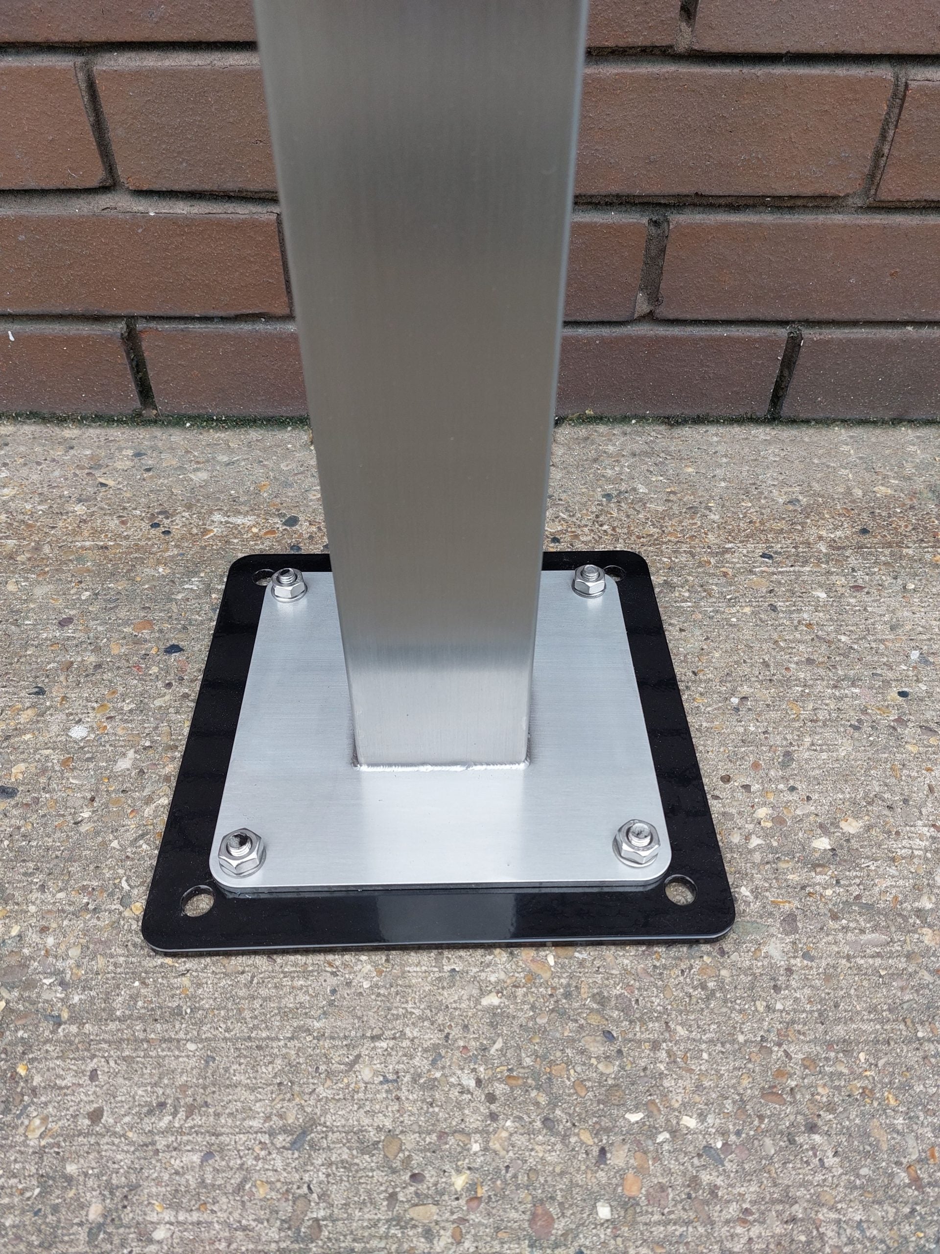 EV charger pedestal floor mounted base installation showing metal post and mounting plate on concrete
