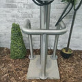 EVCAP Small Wrap EV charger stainless steel cable tidy post installed outdoors against brick wall with cable wrapped