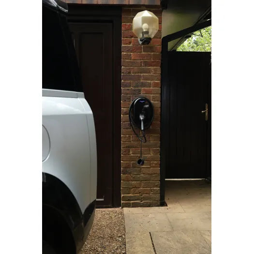 vCHRGD Seven Pro EV charger installed on brick pillar with vehicle charging in driveway - UK home installation
