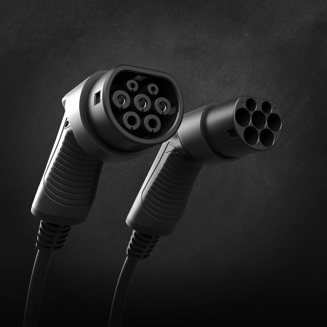 Two Type 2 Mennekes EV charging cable connectors side by side in black on dark textured background, male and female plug face detail