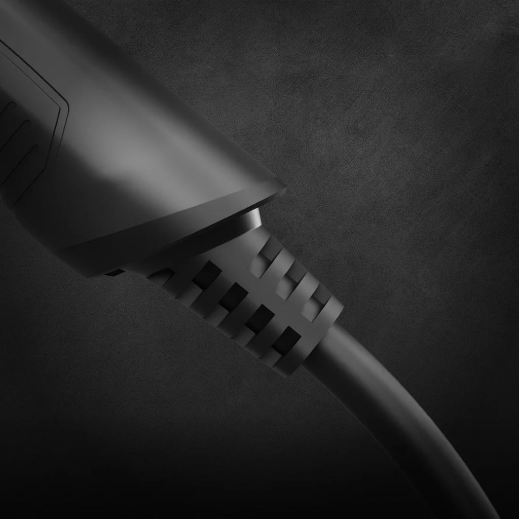 Type 2 EV charging cable connector close-up in matte black on dark textured background showing ribbed strain relief boot and cable