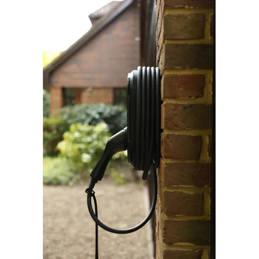 vCHRGD Seven Pro EV charger mounted on brick wall with coiled cable - UK home installation